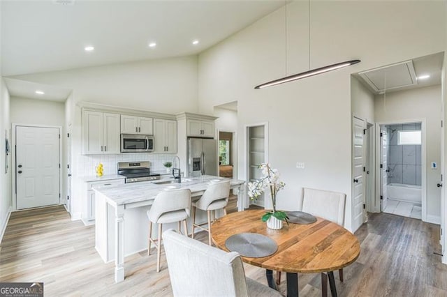 2621 Oldknow Dr NW, Atlanta, GA 30318 - dining space featuring recessed lighting, light wood-style floors, attic access, and vaulted ceiling