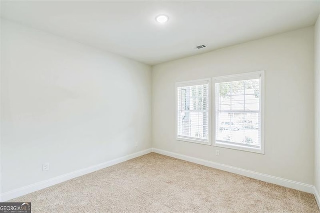 2621 Oldknow Dr NW, Atlanta, GA 30318 - spare room featuring light colored carpet, baseboards, and visible vents