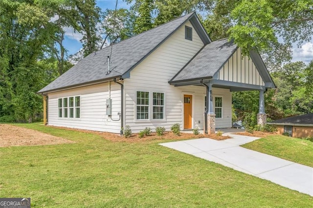 2621 Oldknow Dr NW, Atlanta, GA 30318 - view of front of house featuring a front lawn, board and batten siding, covered porch, and roof with shingles