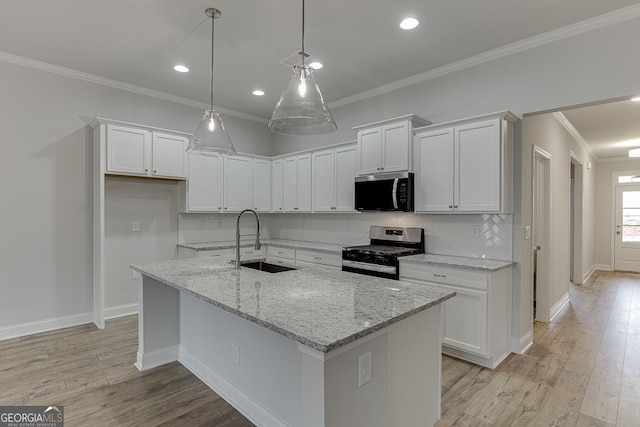 kitchen featuring white cabinetry, appliances with stainless steel finishes, decorative backsplash, and a sink