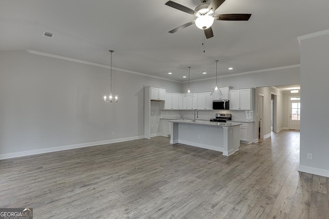 kitchen featuring ceiling fan with notable chandelier, white cabinets, appliances with stainless steel finishes, ornamental molding, and recessed lighting