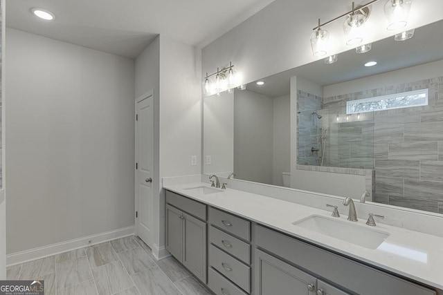 full bathroom with toilet, walk in shower, double vanity, and a sink