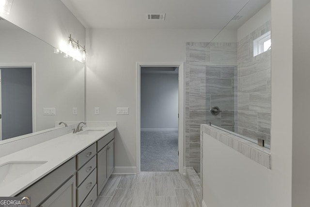 full bath with baseboards, double vanity, a sink, and a walk in shower