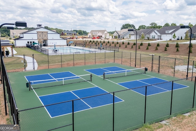 view of sport court with fence and a residential view