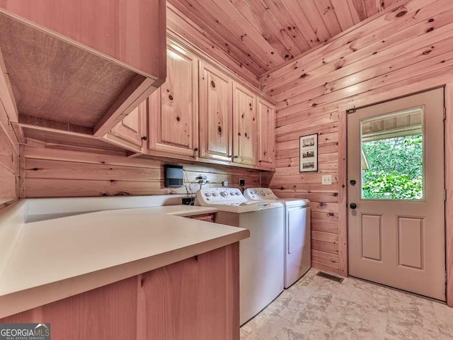 laundry room featuring cabinet space, washing machine and clothes dryer, wood walls, visible vents, and wooden ceiling