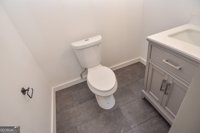 bathroom with vanity, toilet, and baseboards