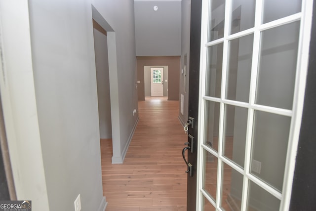 corridor featuring baseboards and light wood-style floors