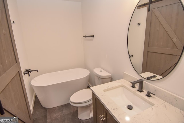 full bath featuring toilet, vanity, and a freestanding tub