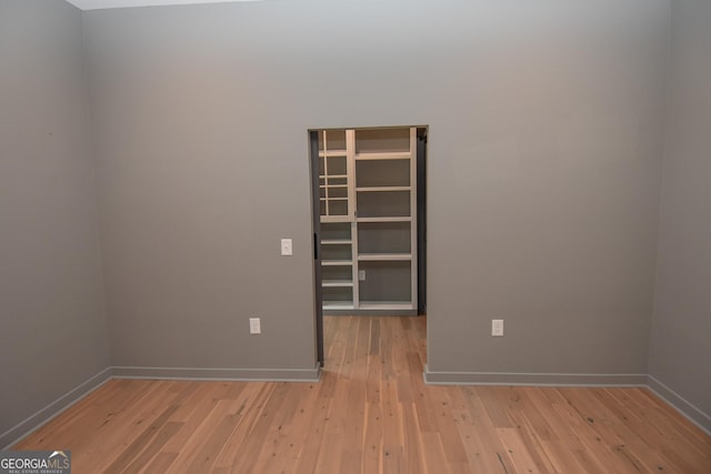 empty room featuring baseboards and hardwood / wood-style floors