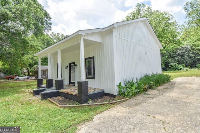 view of home's exterior with covered porch and a yard
