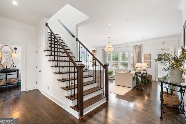 stairway featuring recessed lighting, baseboards, ornamental molding, an inviting chandelier, and wood finished floors