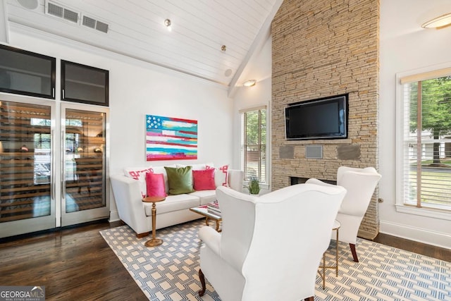 living area with baseboards, wood finished floors, plenty of natural light, and vaulted ceiling