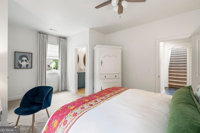 bedroom featuring baseboards, ensuite bath, ceiling fan, visible vents, and light colored carpet