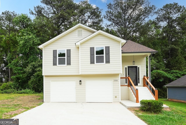 tri-level home featuring an attached garage, a shingled roof, and driveway