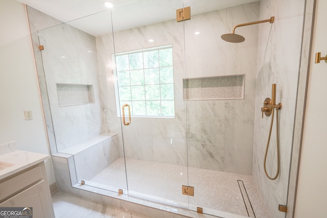 bathroom with vanity, a wealth of natural light, and a marble finish shower