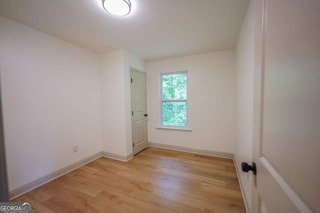spare room with light wood finished floors and baseboards