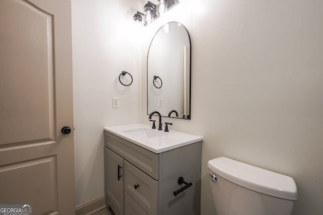 half bath featuring toilet and vanity