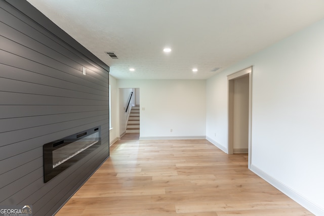 unfurnished living room with visible vents, recessed lighting, a fireplace, light wood-style flooring, and baseboards