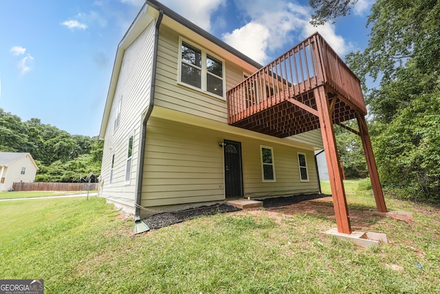 back of house featuring a yard and a wooden deck