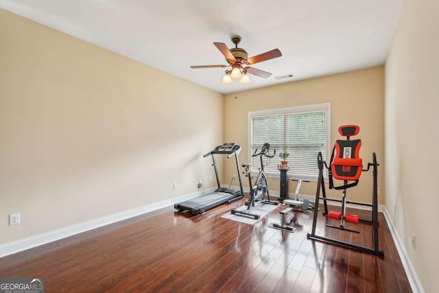 exercise area with baseboards, a ceiling fan, and wood finished floors