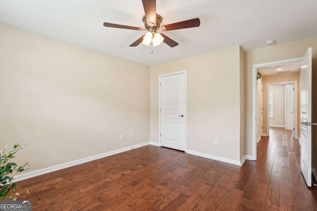 unfurnished bedroom with baseboards, a ceiling fan, and dark wood-style floors
