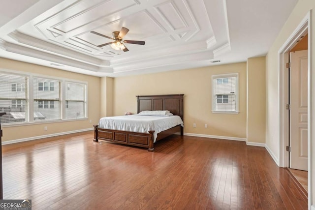 bedroom featuring a tray ceiling, ornamental molding, hardwood / wood-style flooring, and visible vents