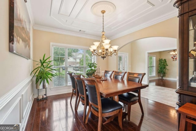 dining space featuring dark wood-style flooring, ornamental molding, arched walkways, and a healthy amount of sunlight