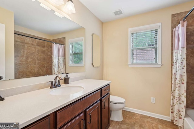bathroom with vanity, toilet, a wealth of natural light, and visible vents