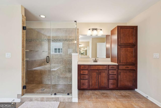 bathroom with a stall shower, vanity, baseboards, and tile patterned floors