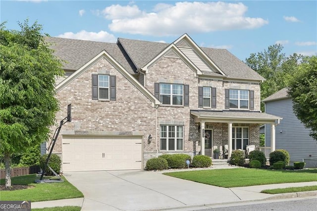 craftsman-style house featuring concrete driveway, brick siding, an attached garage, and a front yard