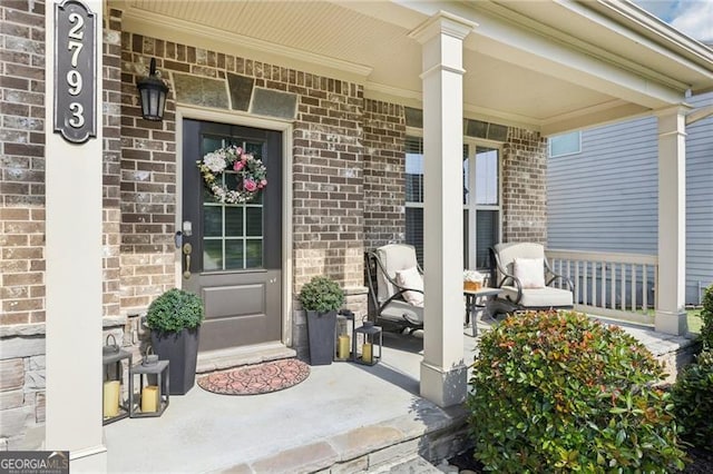 entrance to property with covered porch and brick siding