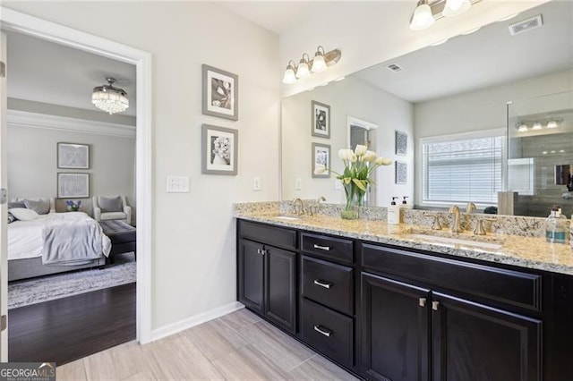 bathroom featuring double vanity, visible vents, baseboards, and a sink