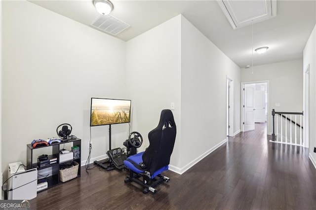 workout room featuring baseboards, visible vents, attic access, and wood finished floors