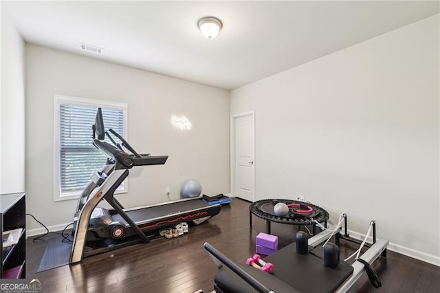 exercise room with baseboards, hardwood / wood-style floors, and visible vents
