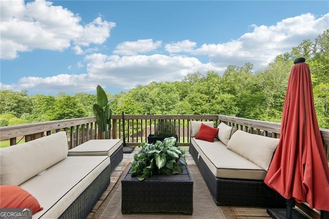 wooden deck featuring an outdoor living space and a forest view