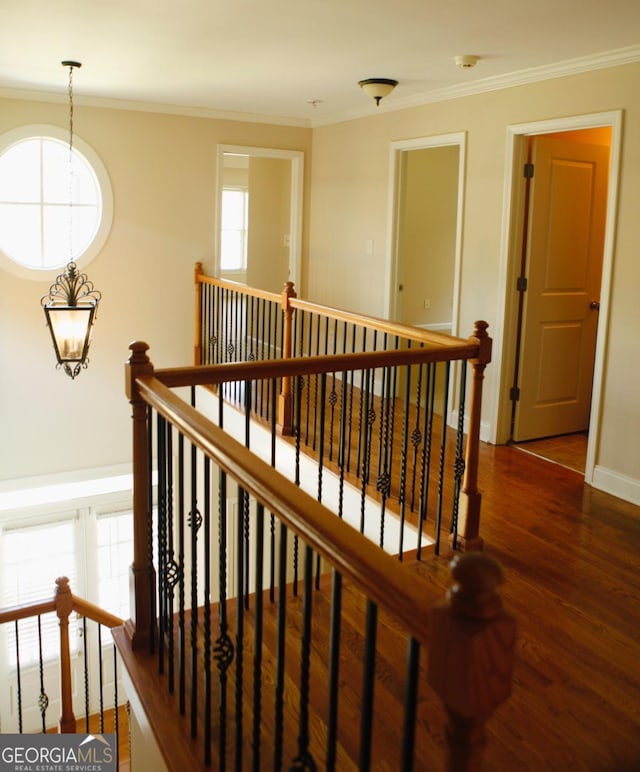 stairs with baseboards, crown molding, and wood finished floors