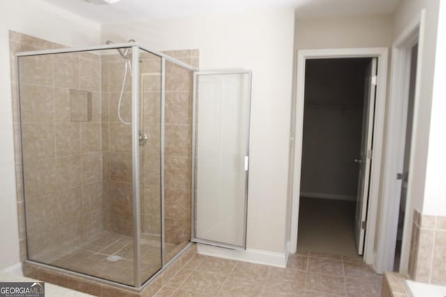 full bathroom with tile patterned floors, baseboards, and a stall shower
