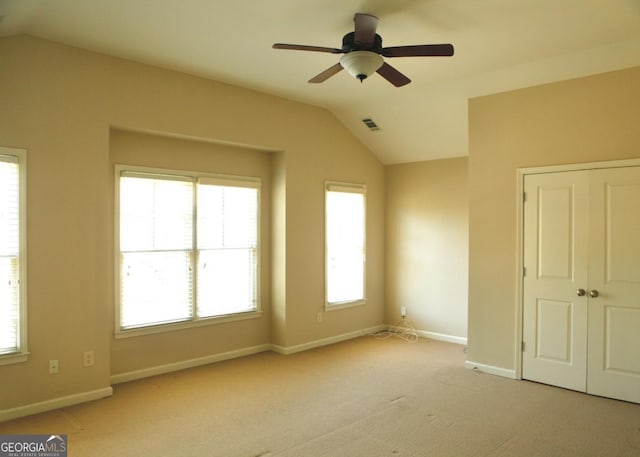 unfurnished bedroom with lofted ceiling, light carpet, and baseboards
