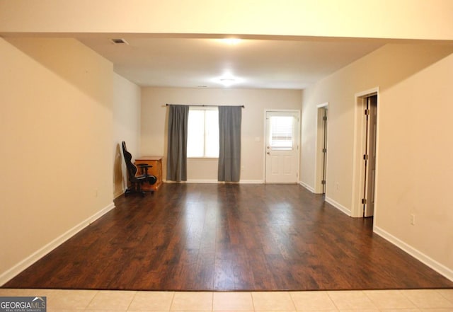 unfurnished living room with wood finished floors and baseboards