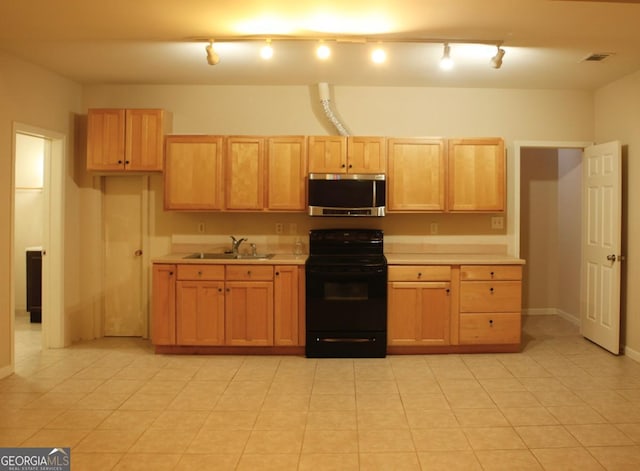 kitchen featuring a sink, black range with electric stovetop, visible vents, stainless steel microwave, and light countertops
