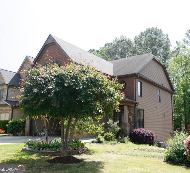 view of front of property with central air condition unit and a front yard