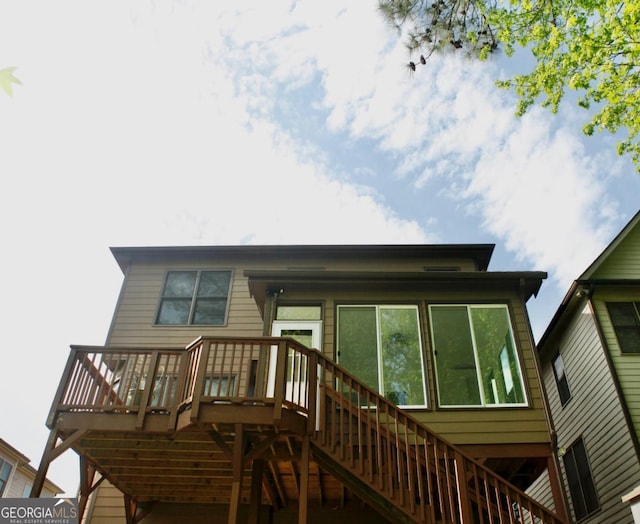 back of house featuring stairs and a wooden deck