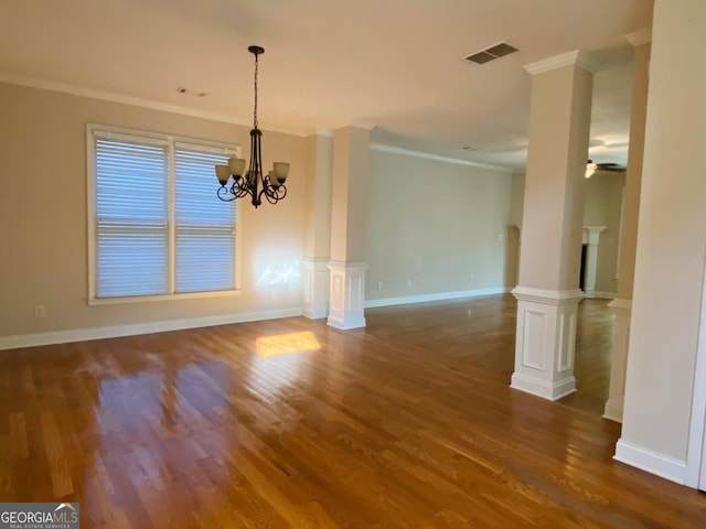 unfurnished dining area with crown molding, visible vents, wood finished floors, and ornate columns