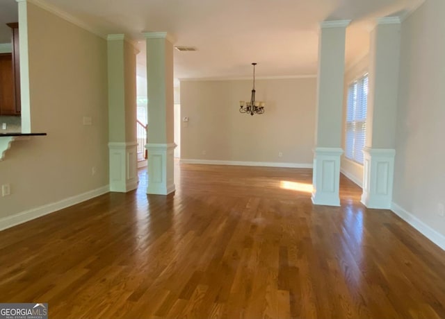 unfurnished dining area with dark wood-style flooring, ornamental molding, and a notable chandelier