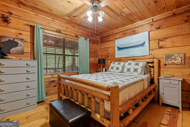 bedroom featuring wooden ceiling, light wood finished floors, and wood walls