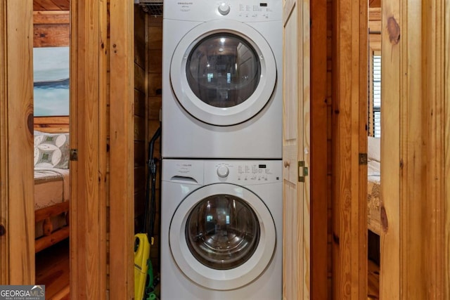 clothes washing area with laundry area and stacked washing maching and dryer