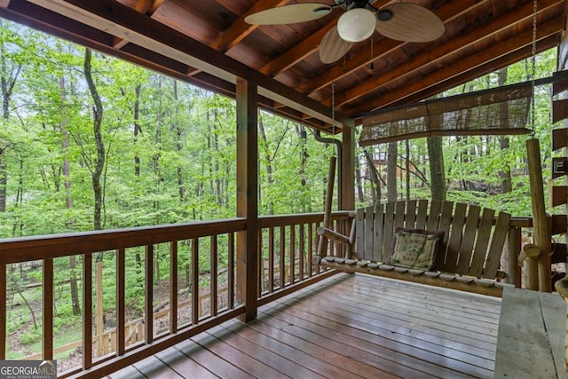 wooden deck with a ceiling fan and a wooded view