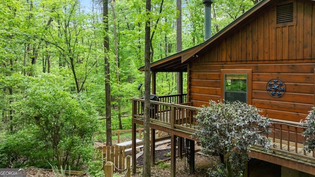 view of side of home featuring a wooded view
