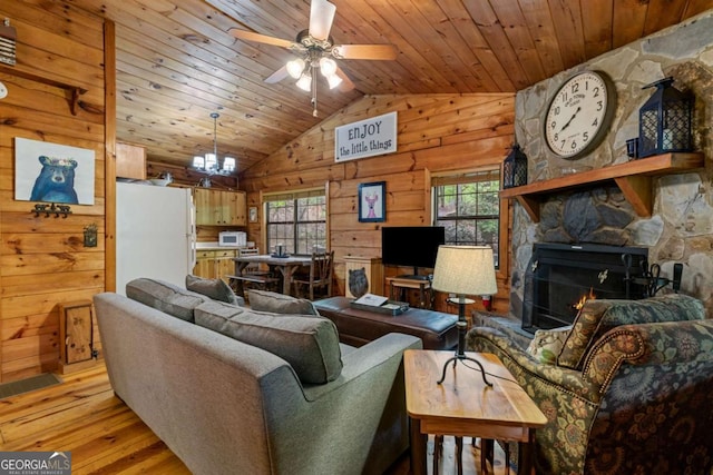 living room featuring wood ceiling, light wood-style flooring, wood walls, ceiling fan, and vaulted ceiling