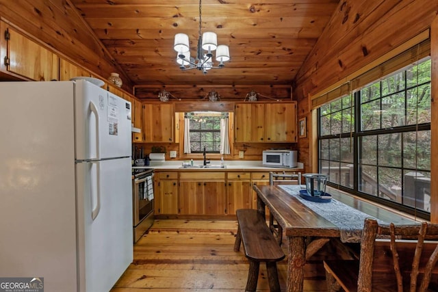 kitchen featuring light countertops, lofted ceiling, a sink, and white appliances